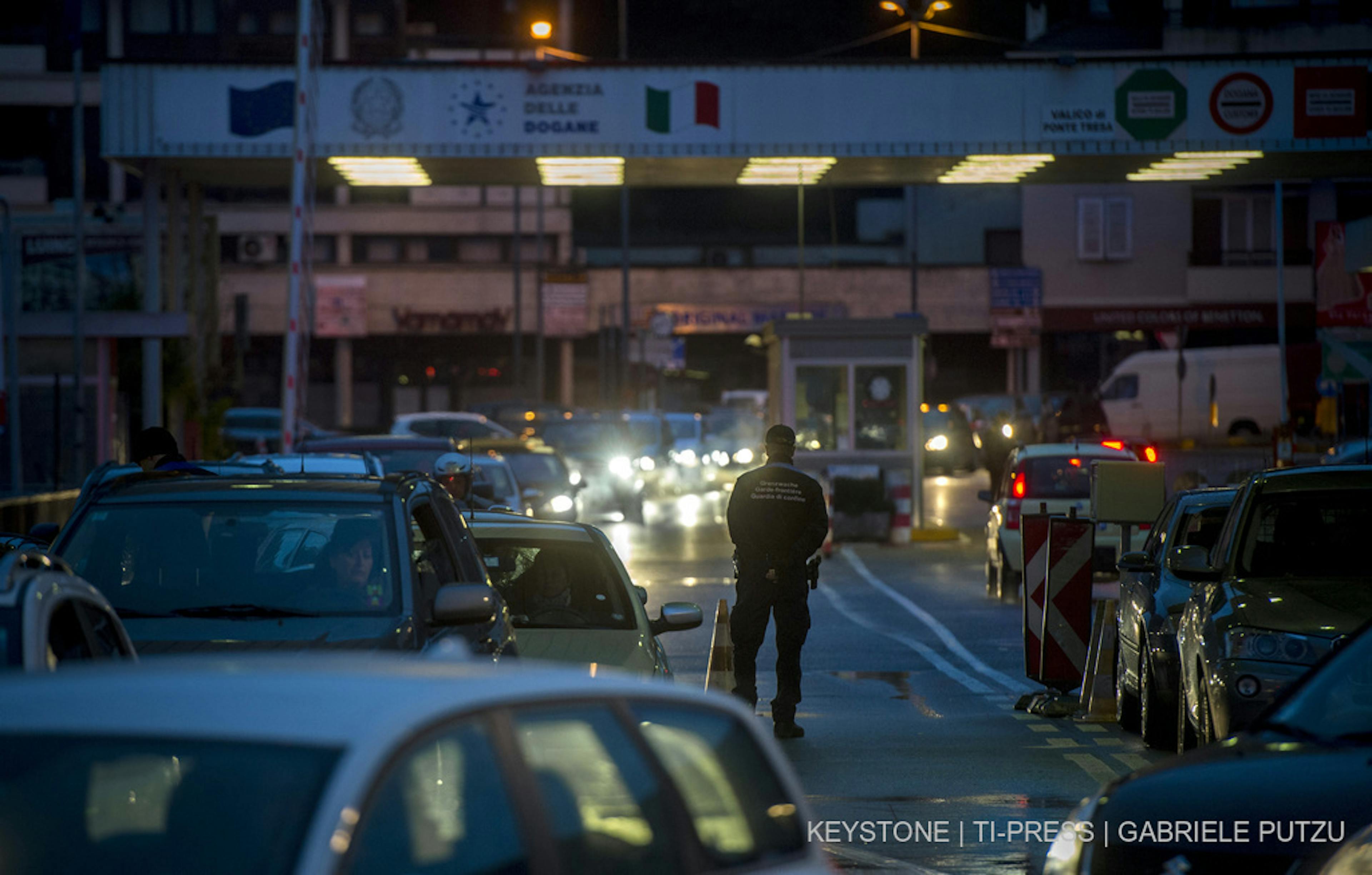 Fahrzeuge mit italienischen Kennzeichen stauen sich am Dienstag abend, 4. Februar 2014, auf ihrem Weg in die Schweiz vor dem Grenzuebergang in Ponte Tresa TI. (KEYSTONE/Ti-Press/Gabriele Putzu)